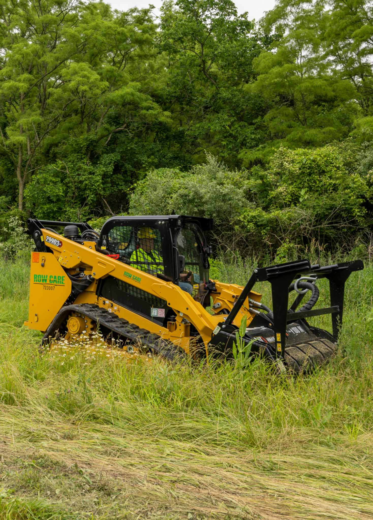 An industrial mower clearing out brush