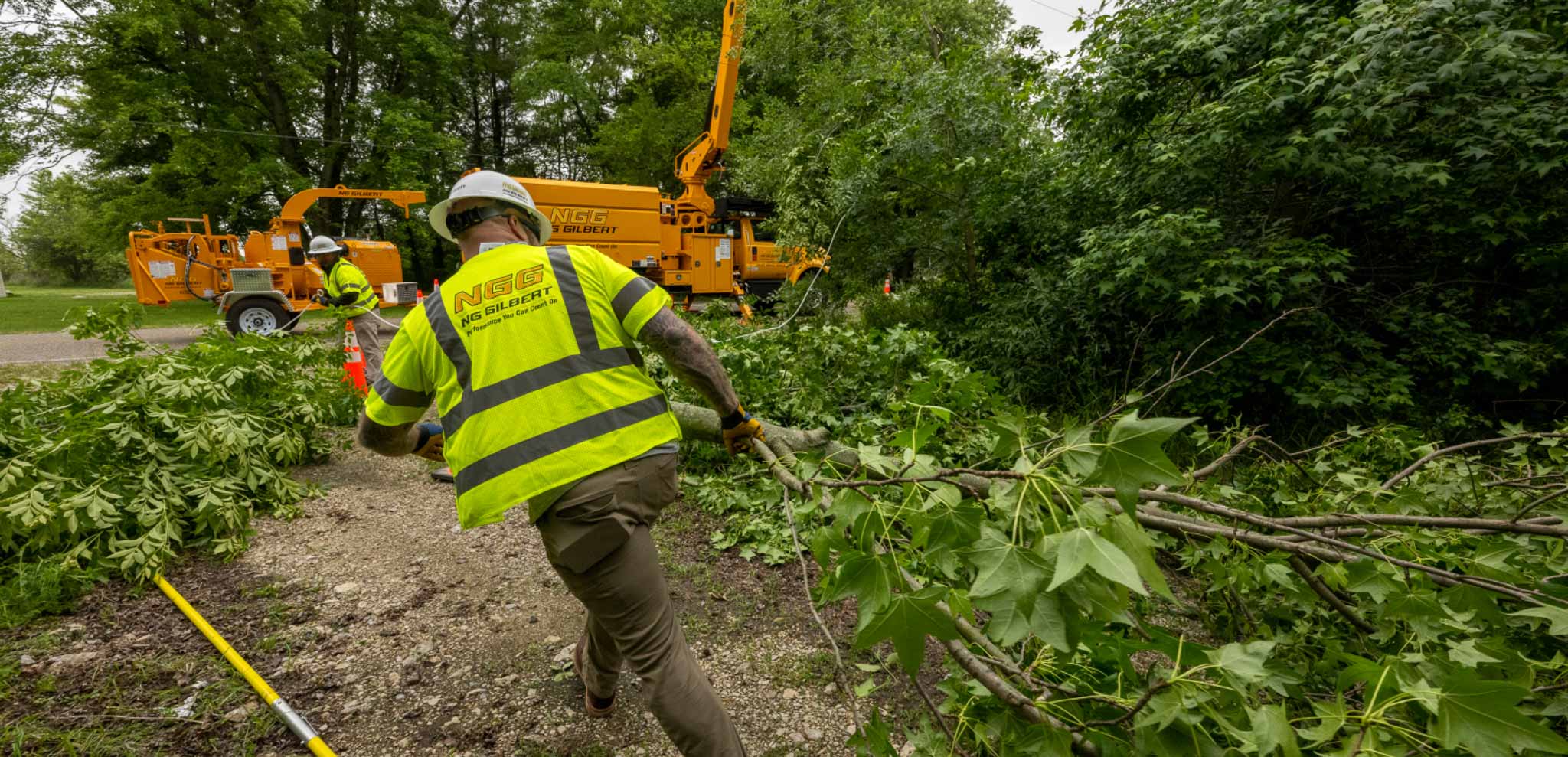 A worker clearing brush after a storm