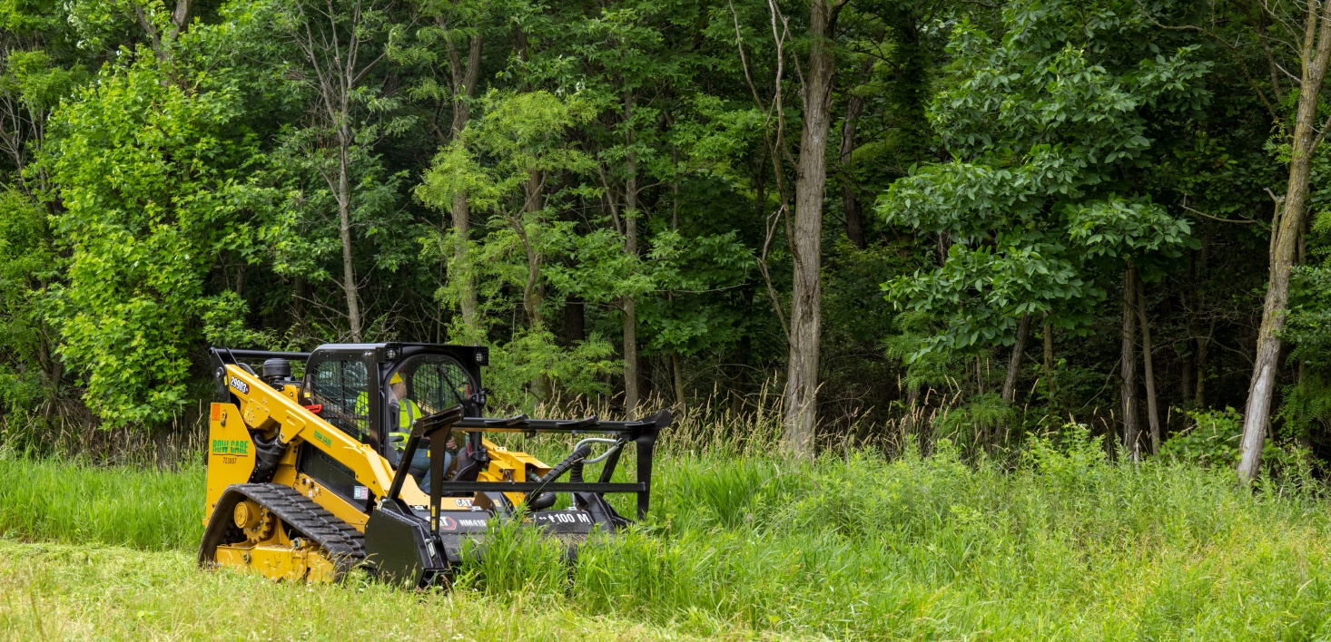 An industrial mower clearing tall grass